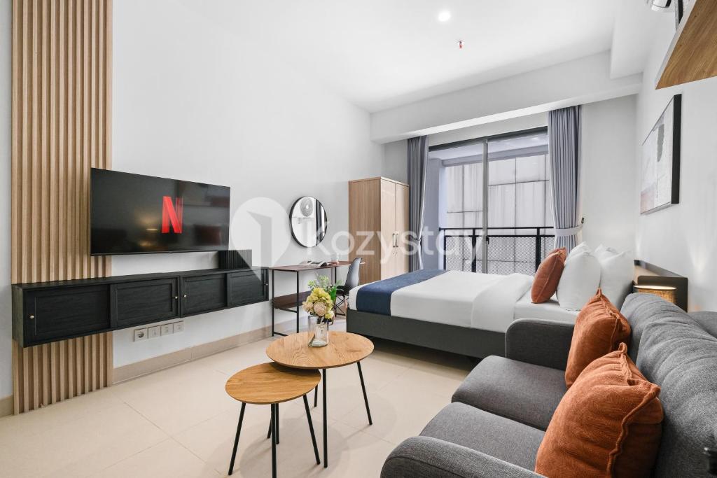 un salon avec un lit et une télévision dans l'établissement Hesrin by Kozystay - Sentul, à Citaringgul 1