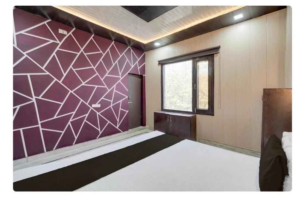 een kamer met een bed en een raam bij Sokoon Home Stay in Morādābād
