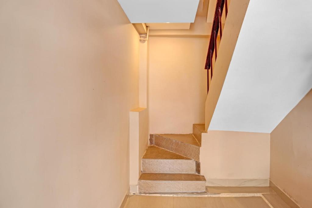 a staircase in a house with a white wall at Hotel O Ramya Inn in Warangal