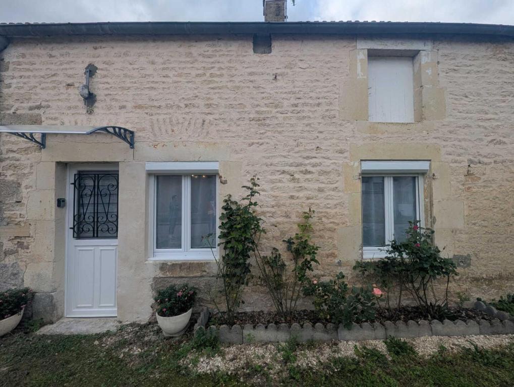 a brick house with a white door and windows at Au petit café in Châteauvillain