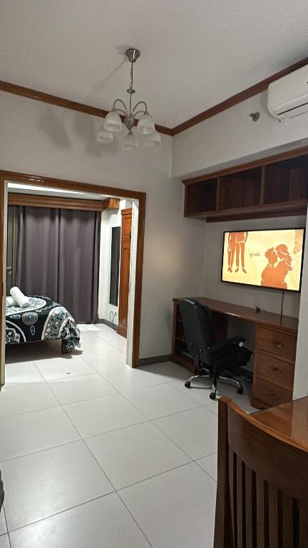 a living room with a television and a bed at KL Rooms at Greenbelt makati with cityview in Manila