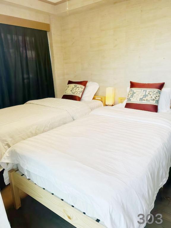 two beds sitting next to each other in a room at 烟雨轩301新 in Tokyo