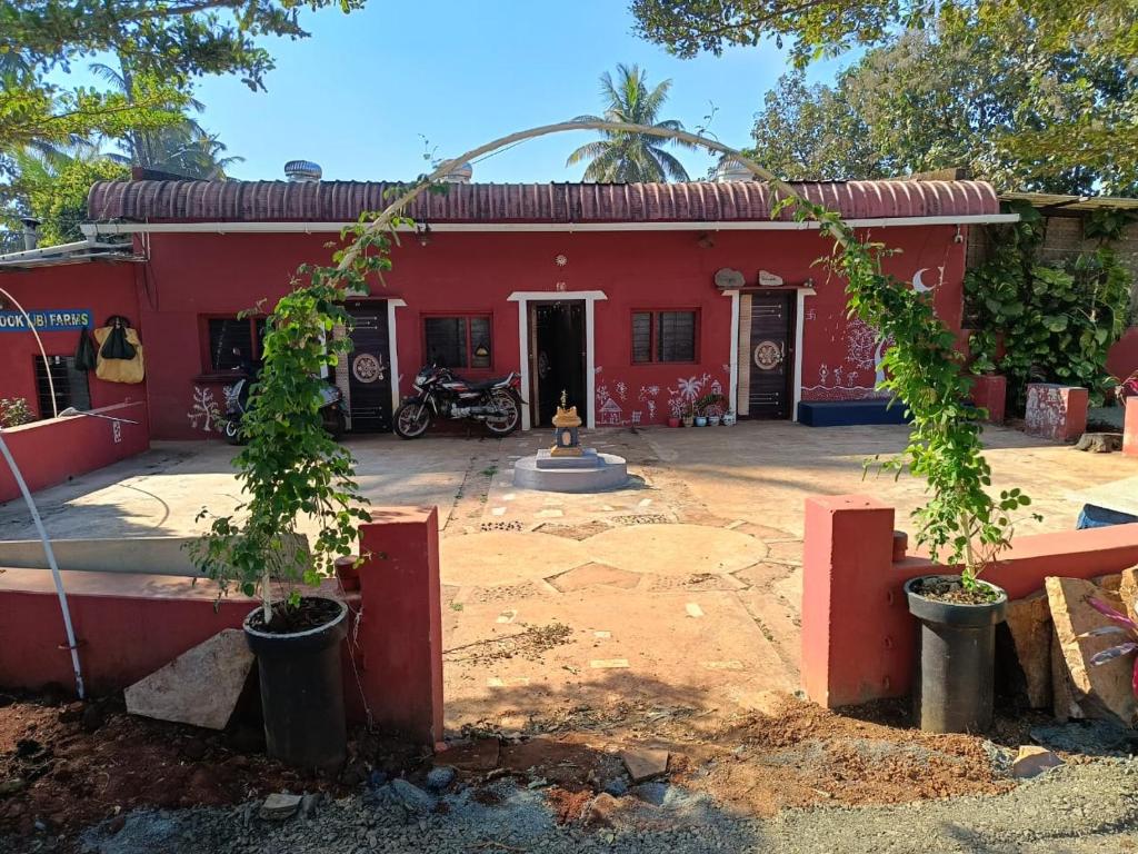 een rood huis met twee bomen ervoor bij PARV Farms in Belgaum