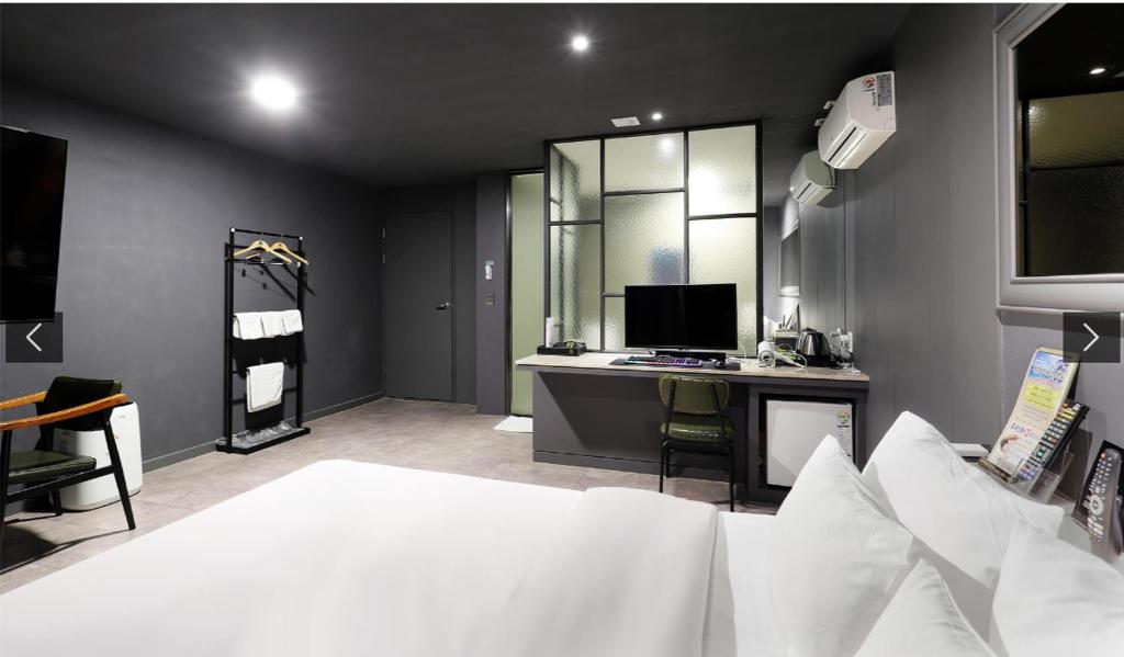 a bedroom with a bed and a desk with a computer at 월호텔 in Pyeongtaek