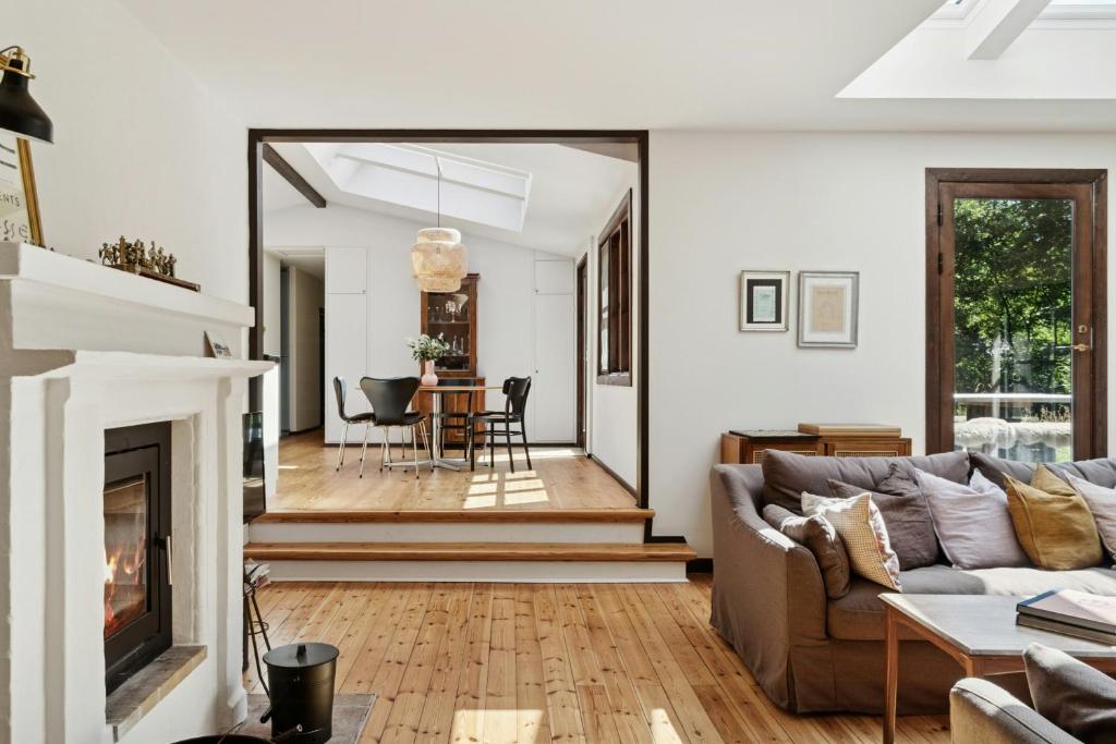 Una sala de estar con un sofá y una chimenea. en Architect Designed With Two Wings By Tisvilde Hegn, en Tisvildeleje