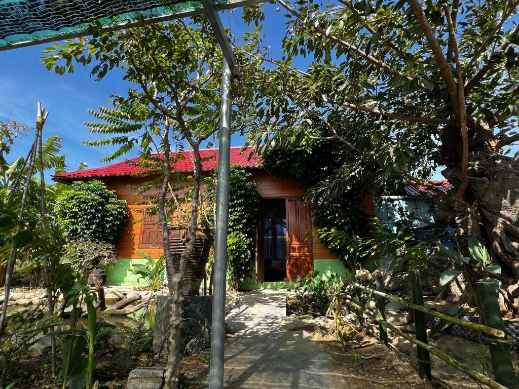 a small house with a red roof at The Rustic Tree Farm in Thôn An Thạnh