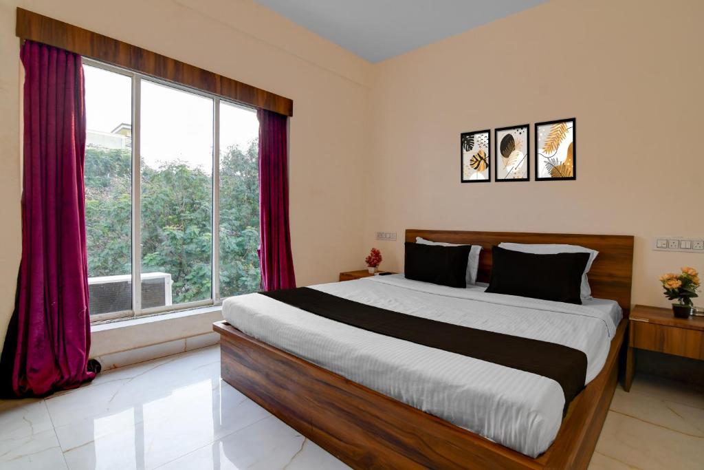 Un dormitorio con una cama grande y una ventana grande. en Super Collection O Biswa Bangla Convention Centre Kolkata Formerly Atithya Inn, en New Town