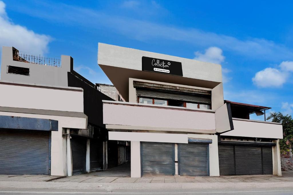 Un edificio con cuatro puertas de garaje en una calle. en Super Collection O Dehradun Central Formerly Hotel Orange Residency, en Dehradun