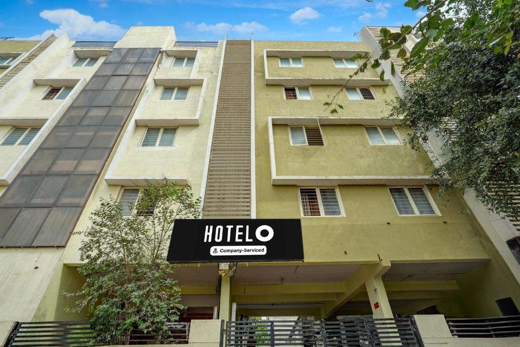 Un edificio con un cartel de hotel enfrente. en Hotel O Thanisandra Railway Station Formerly Urban Drift, en Yelahanka