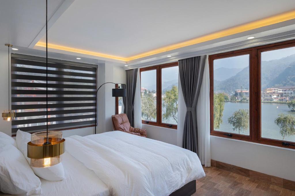 a bedroom with a bed and windows with a view at Monaco Hotel in Sapa