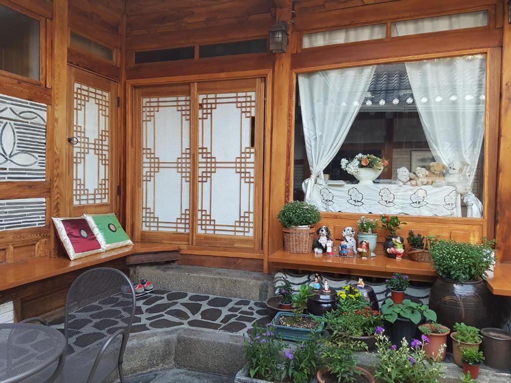 Dajayon Hanok Stay في سول: غرفة مع نافذة مع مجموعة من النباتات