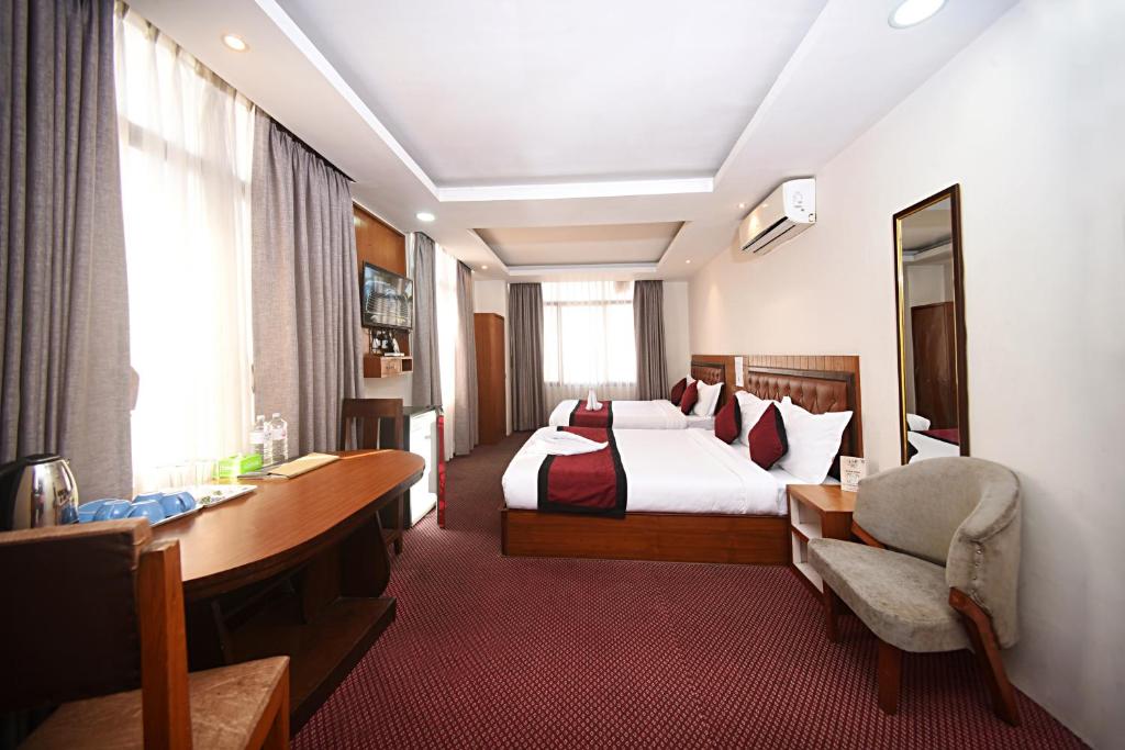 een hotelkamer met een bed en een bureau bij Hotel De Universal in Kathmandu
