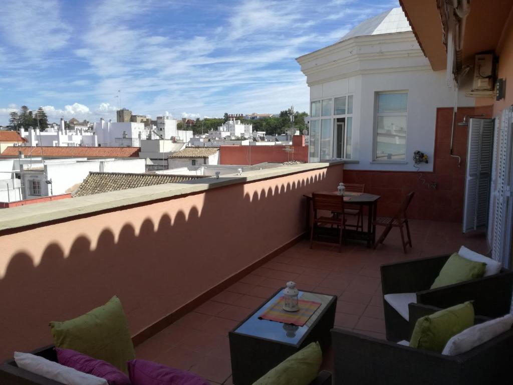 a balcony with couches and a table on a roof at Atico Infanta Eulalia in Sanlúcar de Barrameda