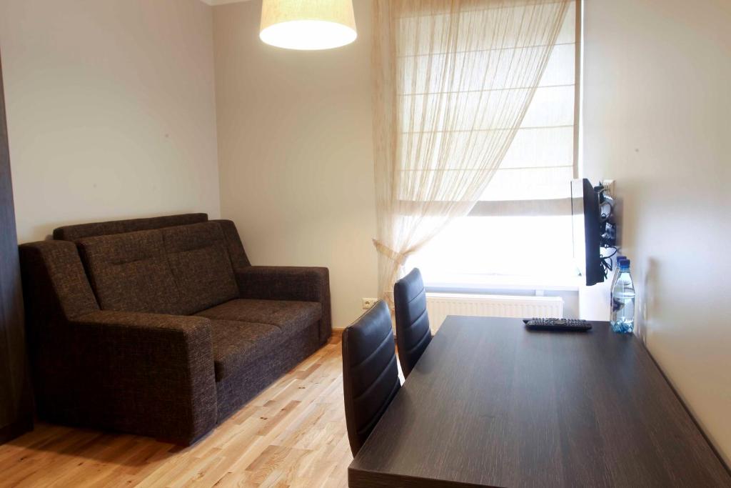 uma sala de estar com um sofá e uma mesa com um computador em Mēness Apartamenti em Cēsis
