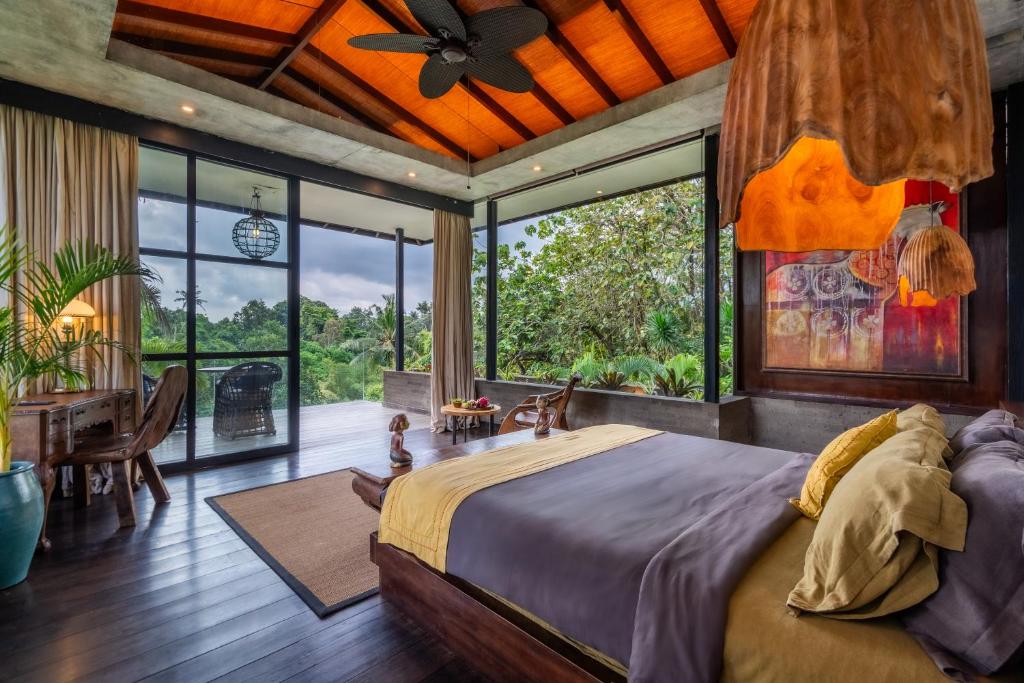 a bedroom with a large bed and a large window at Yara Wellness in Munggu