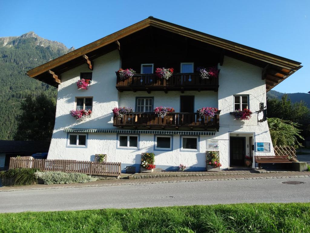 ein weißes Haus mit Blumen auf den Balkonen in der Unterkunft Gästehaus Posch in Krimml