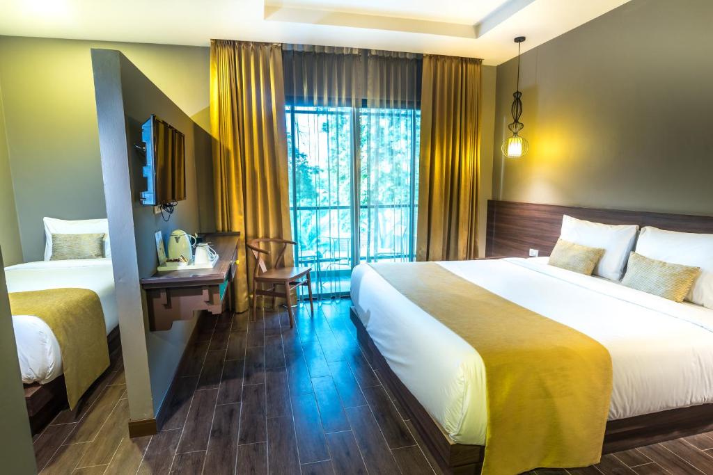 Postel nebo postele na pokoji v ubytování Chiangkhong Teak Garden Riverfront Onsen Hotel- SHA Extra Plus