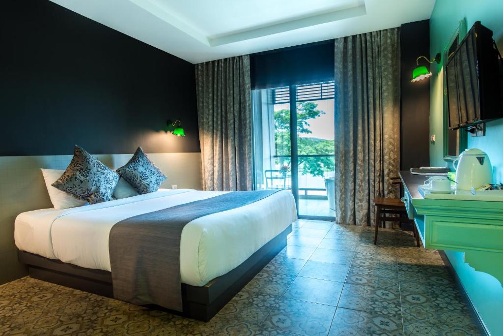 Postel nebo postele na pokoji v ubytování Chiangkhong Teak Garden Riverfront Onsen Hotel- SHA Extra Plus