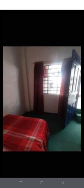 a bedroom with a red bed and a window at Alojamiento Rionegro in Rionegro