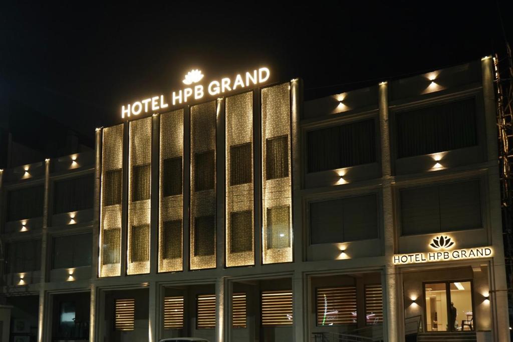 a building with a hotel hog grand at night at Hotel HPB Grand in Bhadohī