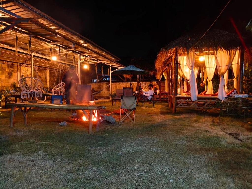 een groep mensen die 's nachts buiten een tent zit bij Hug Pai Garden City Retreat in Pai