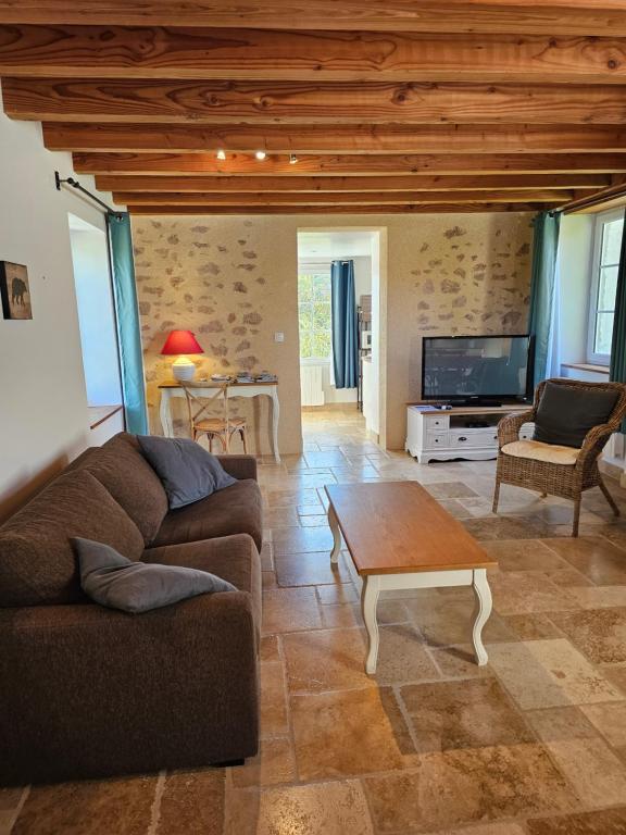 Gîte Le p'tit nid de Montachon, Saulieu, Morvan في Saint-Didier: غرفة معيشة مع أريكة وطاولة قهوة