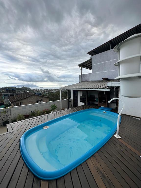 einen großen blauen Pool auf einer Holzterrasse in der Unterkunft Casa com Belas vistas - Muriqui in Mangaratiba