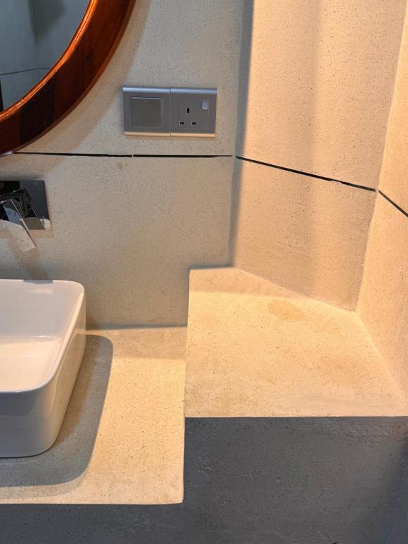 Un baño con inodoro, lavabo y espejo. en Leafy Haven Villa, en Liyanegoda