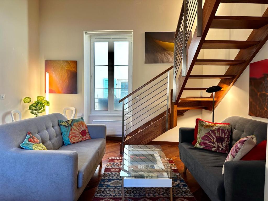 ein Wohnzimmer mit 2 Sofas und einer Treppe in der Unterkunft Rose 2 duplex-clim-plage in Menton