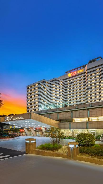a large building with a sunset in the background at Guangdong Hotel in Guangzhou