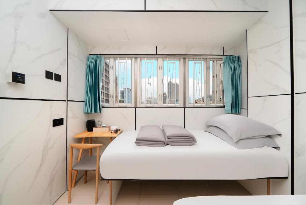 Un dormitorio pequeño con una cama y un escritorio. en Joy Hella Inn, en Hong Kong