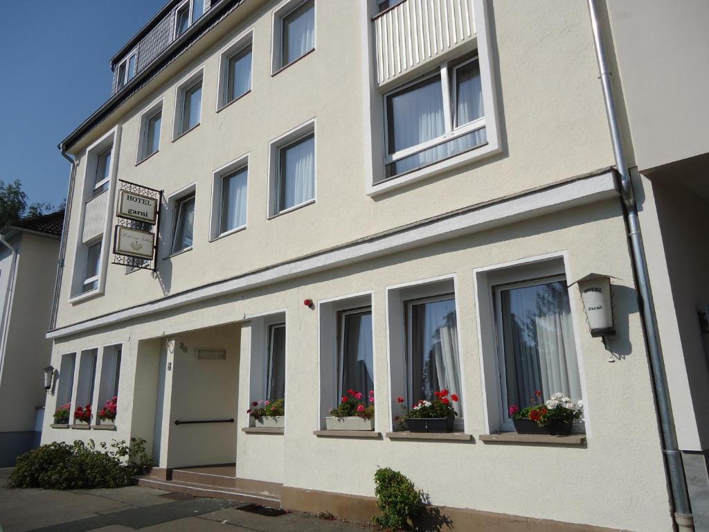 ein weißes Gebäude mit Blumentopfen an den Fenstern in der Unterkunft Hotel am Schloss in Hannover