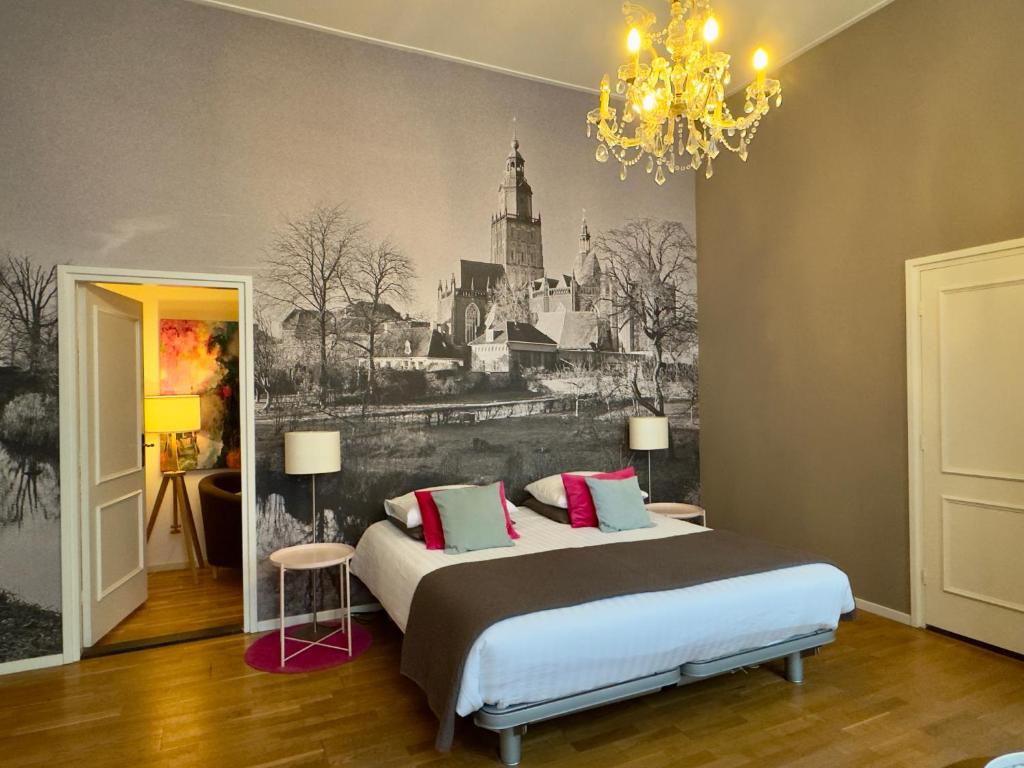 a bedroom with a bed with a painting on the wall at B&B Kerkstraatje3 midden in historisch centrum in Zutphen