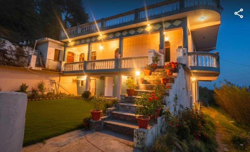 a large house with stairs in the yard at night at The Gypsy Soul Mukteshwar in Mukteshwar