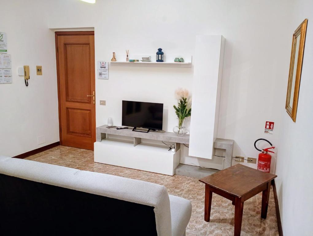 een woonkamer met een televisie en een tafel bij La casa di Sergiò in Belgioioso