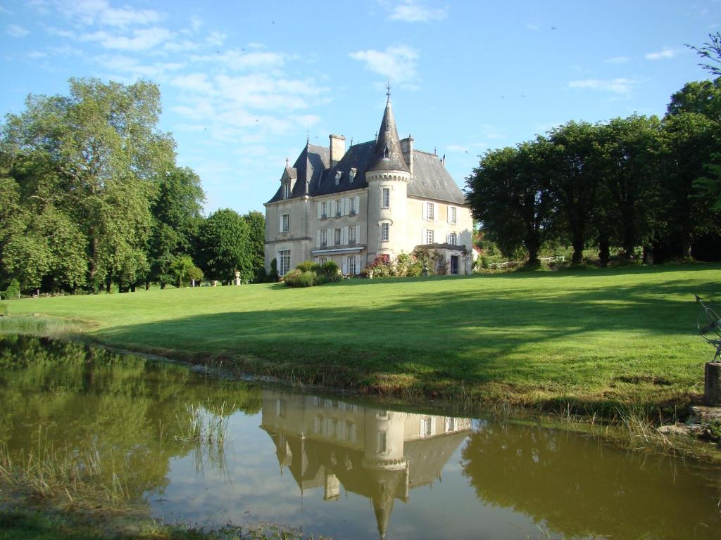 ein altes Schloss mit einer Spiegelung in einem Gewässer in der Unterkunft Château de la Chabroulie in Isle