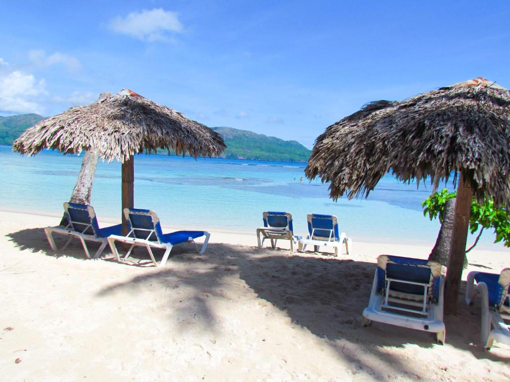 a group of chairs and umbrellas on a beach at Las Galeras Hotel in Las Galeras