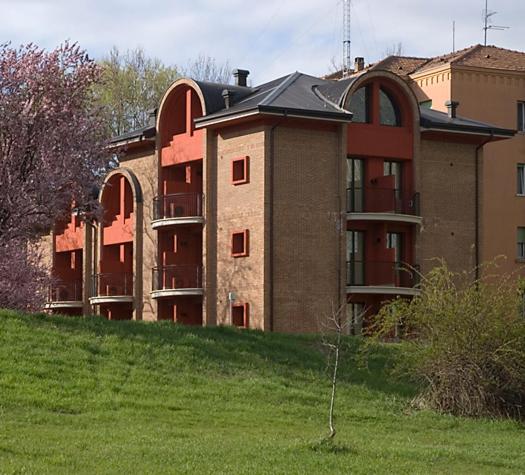 a large building on top of a grassy hill at Residence Le Volte Apartments in Parma