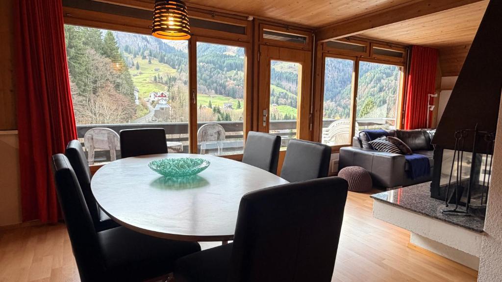a dining room with a table and chairs and a large window at Chalet Engelberg Mountain View in Engelberg