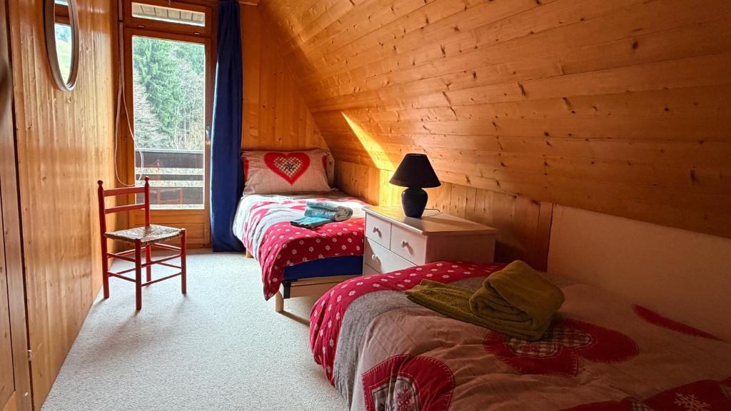 een slaapkamer met 2 bedden in een houten hut bij Chalet Engelberg Mountain View in Engelberg
