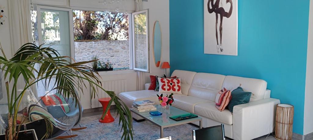 a living room with a white couch and a table at La Pause Bleue in Dinard