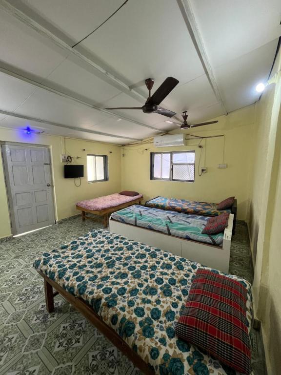 - une chambre avec 2 lits et une télévision dans l'établissement Dwarka holiday home, à Nagaon