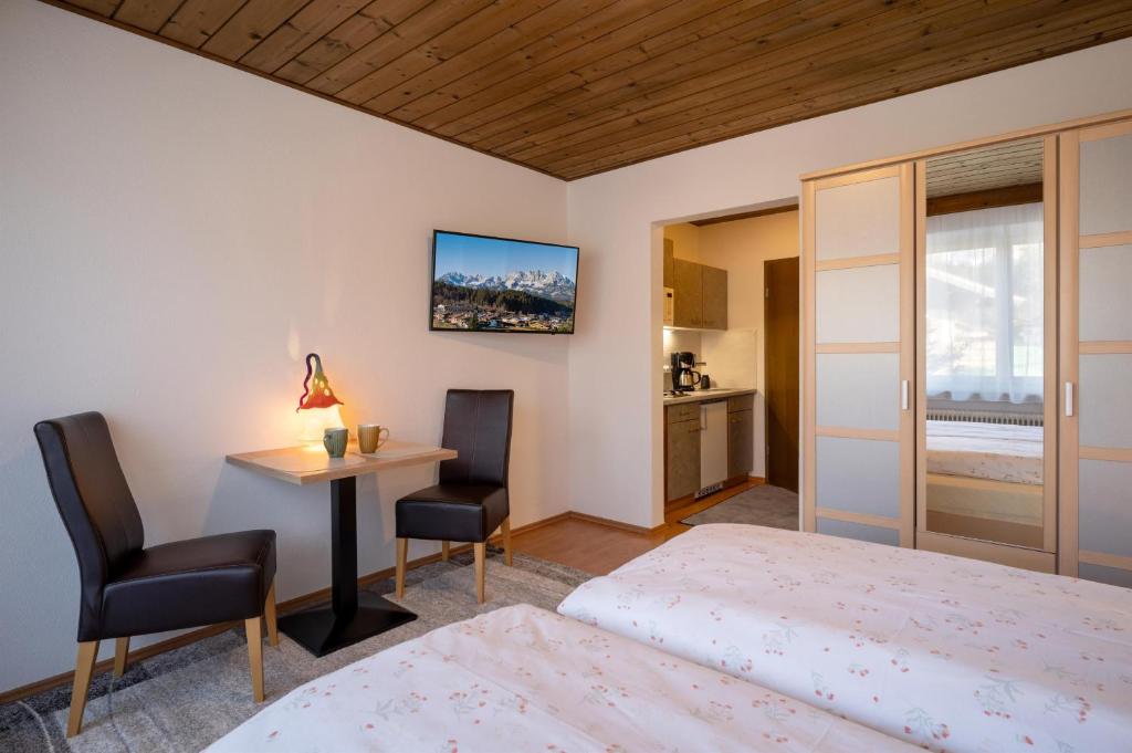een slaapkamer met twee bedden en een tafel en stoelen bij Haus St. Michael in Oberndorf in Tirol