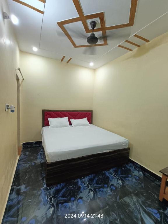 a bedroom with a bed with a painting on the floor at Hotel Maa Dham Palace in Ayodhya