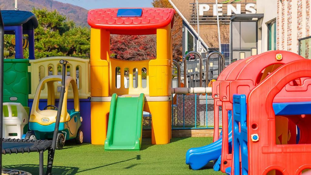 a playground with colorful play equipment in front of a building at Gapyeong Ttonggangaji Kids Poolvilla in Gapyeong