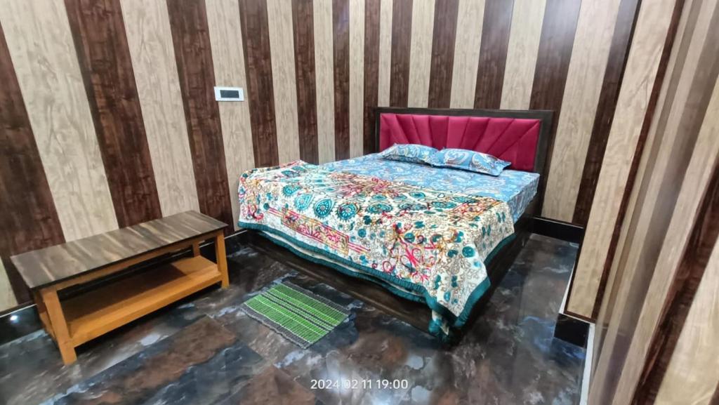 a small bedroom with a bed and a table at Hotel Maa Dham Palace in Ayodhya