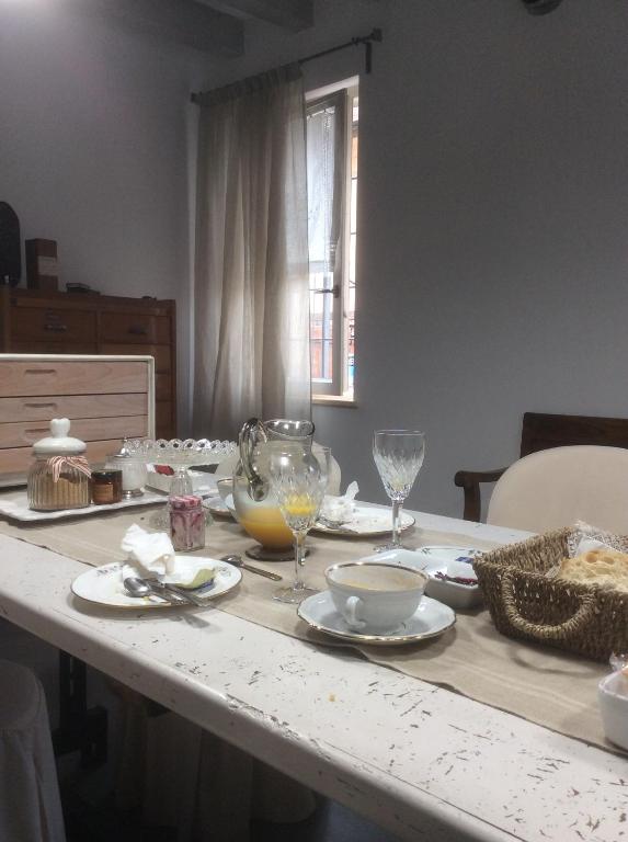 een tafel met borden en wijnglazen erop bij Appartamento73 in Cignone