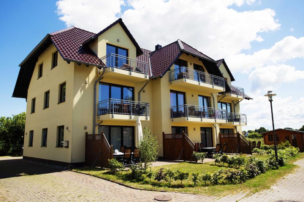 a large yellow building with a roof at Villa Boddenblick in Wiek auf Rügen