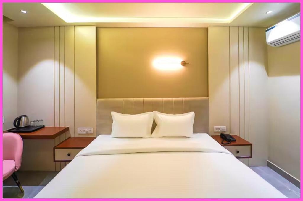 Un dormitorio con una gran cama blanca con dos almohadas. en Rooftop Sea View & BALCONY ROOMS RR In Near JNear Jagannath Temple - Golden Beach- Swargadwar Beach - Bengali Market - Free Wi-fi and parking- Fully Air Conditioning Rooms - Best Hotel, en Puri