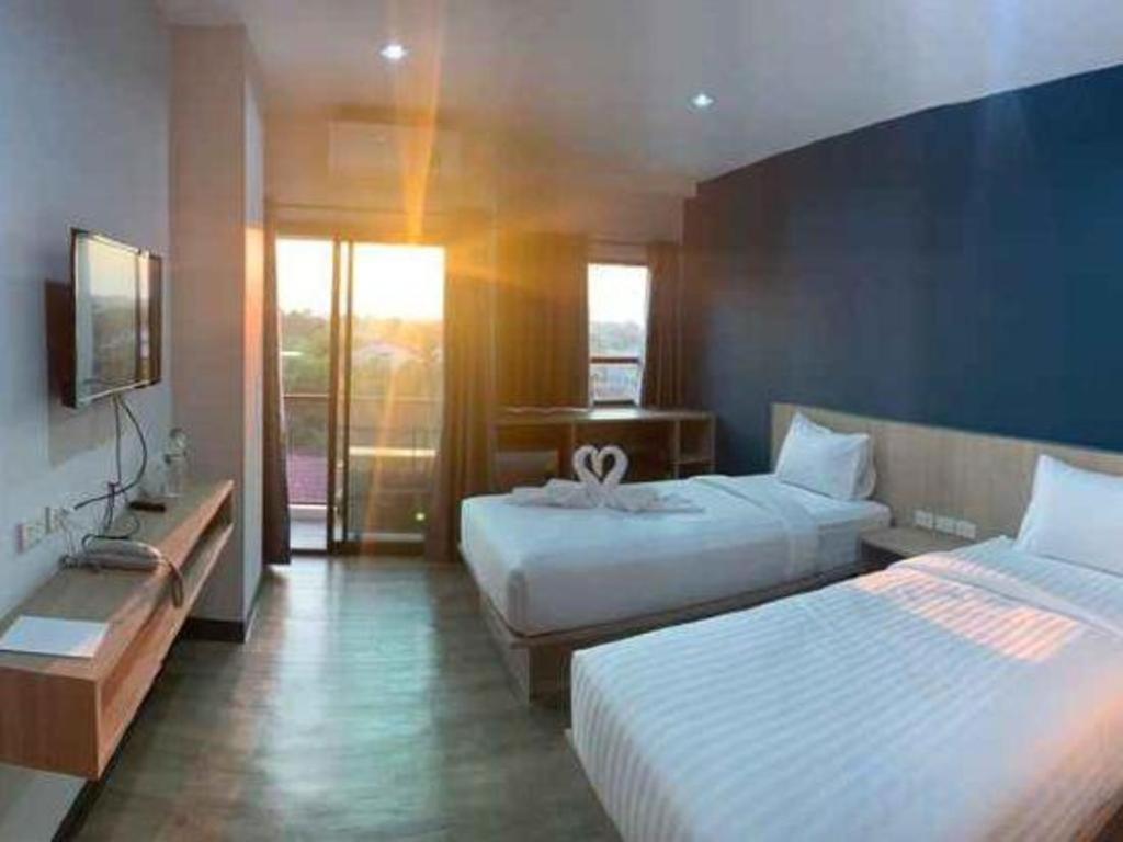 Ban Na KhwaiにあるTripper Hotelのベッド2台とテレビがあるホテルの部屋